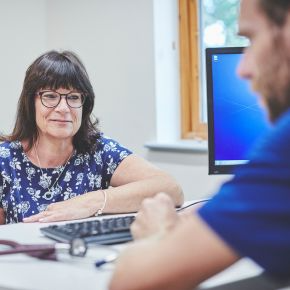 A referral vet sits at their desk, advising a client