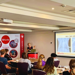 A presenter delivering a veterinary CPD talk at last year's Surfari CPD event, with attendees seated at tables and a projected slide visible on screen