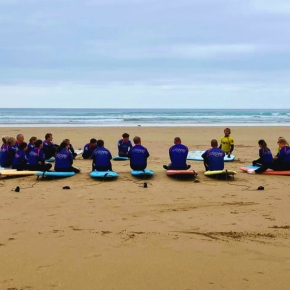 Several people sat on surfboards during a surfing lesson on the beach